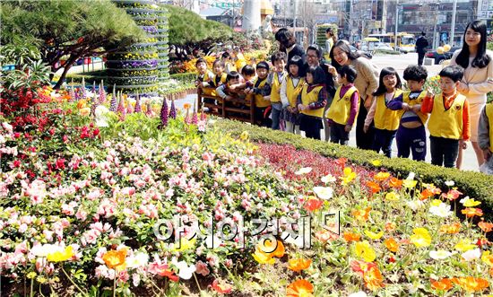 28일 중흥어린이집 원생들이 광주 북구청 광장에 활짝 핀 봄꽃을 바라보며 환하게 웃고 있다. 주민과 함께하는 봄꽃잔치는 광주 북구청광장에서 다음달 7일까지 열린다. 이번 봄꽃잔치에서는 미니팬지, 페튜니아, 마가렛, 금잔화, 데이지, 튤립 등 60만송이 봄꽃을 선보인다. 