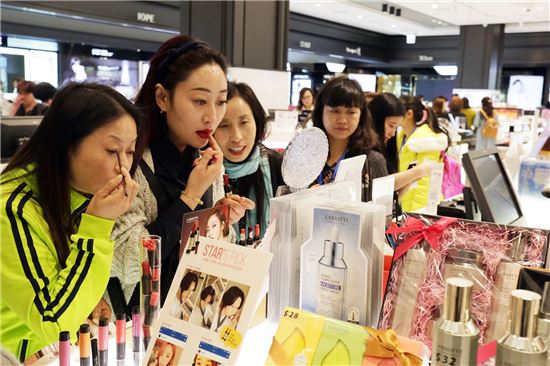 4월1일 서울 여의도 갤러리아면세점 63을 찾은 아오란그룹 임직원들이 화장품 매장을 방문해 제품을 고르고 있다. 