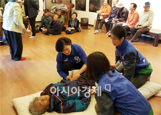 우윤근 후보의 부인인 위희욱(53)씨가  쓰러진 할머니를 응급처지를 하고있다.