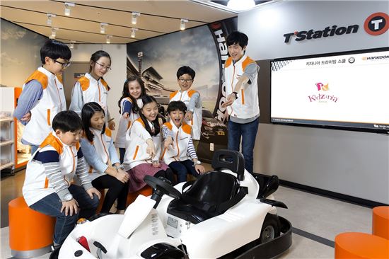 한국타이어가 오픈한 '키자니아' 센텀시티점 모터스포츠 체험 공간을 찾은 어린이들이 교육용 자동차를 보면서 활짝 웃고 있다. 