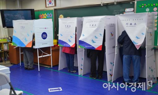 20대 국회의원 선거가 진행되고 있는 13일 유권자들이 기표소에서 투표를 하고 있다.