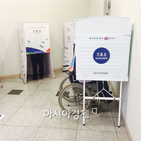 서울 용산 한강로동 제1투표소에서 휠체어를 타고 온 유권자가 투표를 하고 있다.