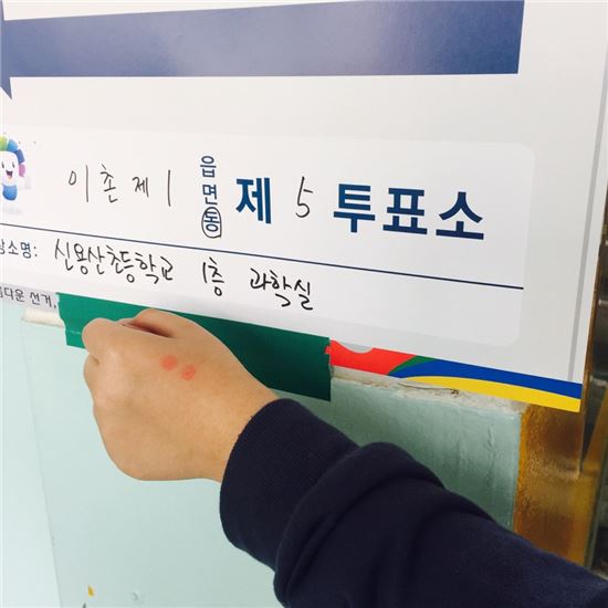 서울 신용산초등학교에 설치된 이촌제1동 제5투표소에서 투표를 마친 추계예술대학교 15학번 원정문(21)씨가 기표 도장을 찍은 손등을 들어 보이고 있다.