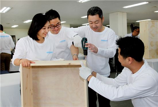 박정원 두산그룹 회장(오른쪽에서 두번째) 독거노인들에게 전달할 가구를 제작하고 있다. 