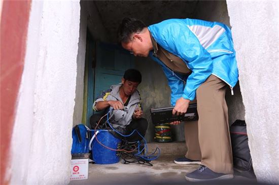 ▲이번 연구에 참여한 북한 과학자 두 명이 지진계 설치 작업을 하고 있다.[사진제공=사이언스 어드밴스]