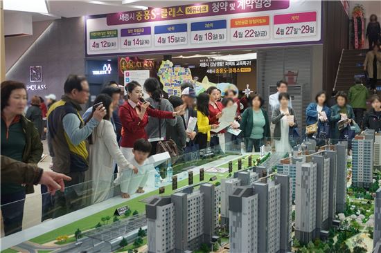 중흥S-클래스 에듀마크 견본주택 방문객들이 아파트 단지 모형을 살펴보고 있다.