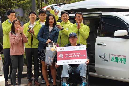 기아자동차 관계자 등이 20일 초록여행 2만번째 고객으로 선정된 강용남씨(앞줄 오른쪽)에게 특수 제작된 '카니발 이지무브' 차량 전달식을 열고 기념촬영을 하고 있다.