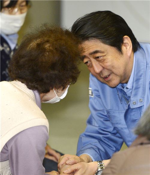 아베 신조 일본 총리가 23일 구마모토 현의 대피소를 찾아 이재민들을 위로하고 있다. (AP = 연합뉴스)