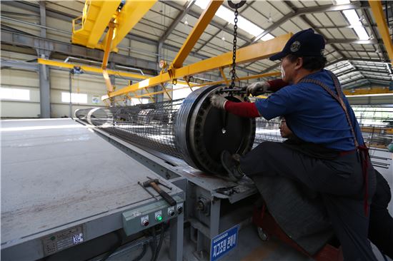 충남 아산에 위치한 아주산업 아산사업소에서 근로자가 고강도 콘크리트파일(PHC파일)을 만들고 있다.