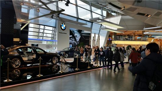 BMW벨트를 방문한 관람객들이 전시된 차량들을 보고 있다.