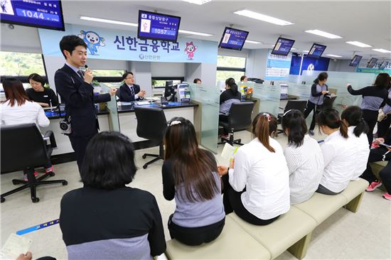 신한은행 직원이 29일 서울 광화문 소재 신한금융교육센터에서 북한이탈주민들을 대상으로 진행한 금융체험교육 중 교육참가자들에게 은행창구에서 이루어지는 업무에 대해 설명하고 있다. (사진 : 신한은행)