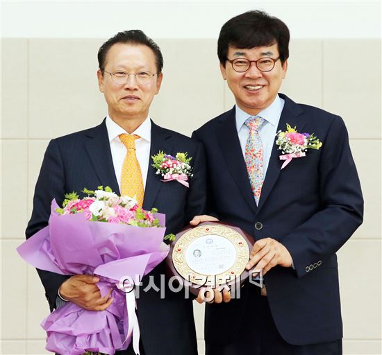 올해 군민의 상을 수상한 기업인 문주현 대표(왼쪽)가 김성 장흥군수와 기념촬영을 하고있다.