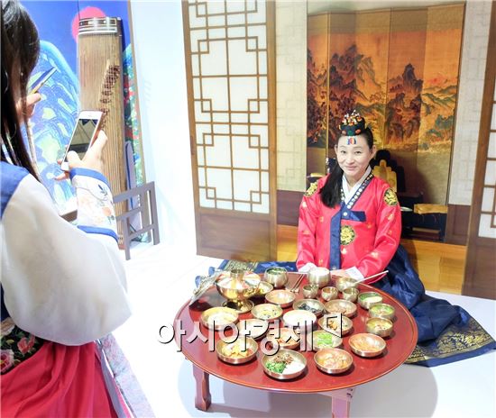 5일(현지시간) 중국 상하이 국제식품박람회(2016 SIAL CHINA) 한국관을 찾은 중국인 관광객이 한복을 입고 한국 전통 반상 앞에서 카메라를 향해 포즈를 취하고 있다.(사진=오종탁 기자)    