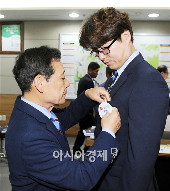 올해 첫 광주광역시‘1일 시민시장’에 선정된 환경 전문가 박종석 씨에게  윤장현 시장이 시민시장 배지를 달아주고있다.