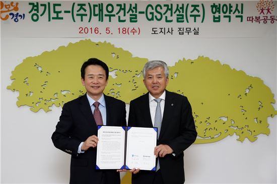 남경필 경기도지사(왼쪽)과 박영식 대우건설 사장이 마을공동체 프로그램 '따복공동체' 활성화를 위한 업무협약을 체결하고 기념촬영을 하고 있다.