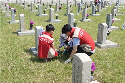 롯데건설 임직원 가족들이 지난 28일 서울 국립 현충원을 방문해 묘역단장을 하고 있다.(자료:롯데건설) 