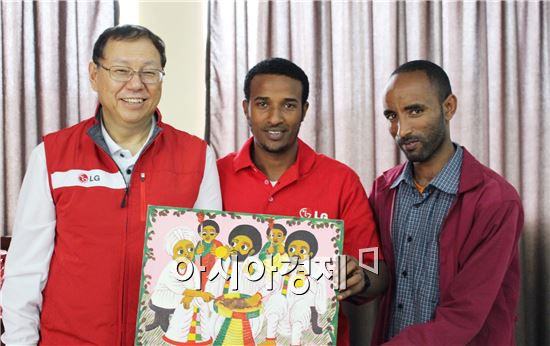 조성진 LG전자 사장 사장(왼쪽에서 첫번째) LG-KOICA 희망직업훈련학교 학생에게 선물받은 그림을 들고 사진 촬영을 하고 있다.(제공=LG전자)