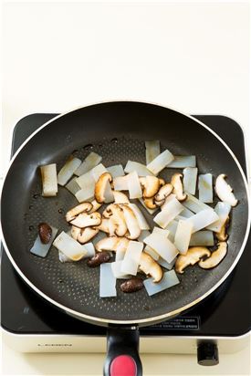 3. 표고버섯이 어느 정도 익으면 곤약을 넣고 간장, 맛술, 설탕, 다진 마늘을 넣어 볶는다.
