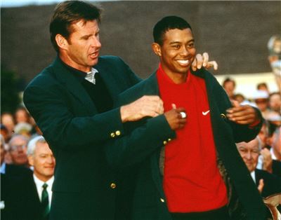 닉 팔도(왼쪽)가 1997년 마스터스에서 우승한 타이거 우즈에게 그린 재킷을 입혀주고 있는 모습. 사진=마스터스 홈페이지