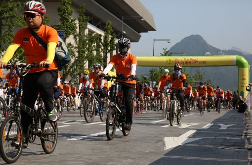 알톤스포츠가 후원한 ‘셰어더로드 자전거 퍼레이드 2016’에서 참가자들이 오렌지색 셔츠를 입고 광화문 광장을 출발하고 있다.