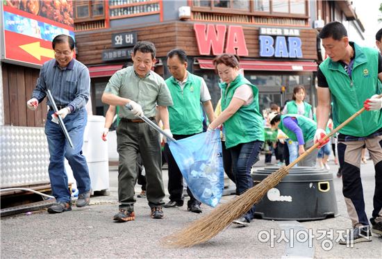 윤장현 광주광역시장은 15일 오전 북구 용봉동 비엔날레 광장에서 내 집 앞 내가 쓸기’청결운동에 참여해 음식물쓰레기 줄이기 캠페인을 하고 용봉동 주택가 도로를 청소하고 있다. 사진제공=광주시