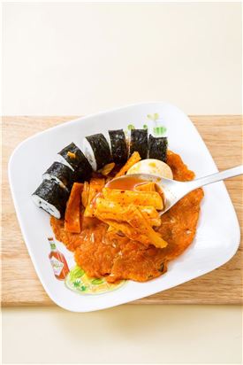 3. 접시에 김치전을 깔고 김밥을 먹기 좋은 크기로 썰어 넣고 떡볶이를 얹는다.
