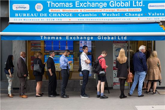 ▲22일(현지시간) 영국 런던 시내 은행에서 환전을 하기 위해 줄지어 선 시민들의 모습(사진=블룸버그)