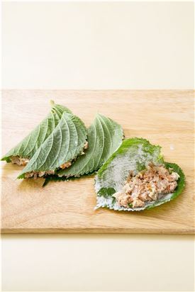 4. 깻잎 안쪽에 밀가루를 묻히고 깻잎의 반에 준비한 소를 얹고 덮어 밀가루와 달걀물을 묻힌다. 
