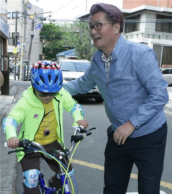 유종필 관악구청장이 자전거 타기를 소원한 아이에게 자전거를 전달하며 격려하고 있다.