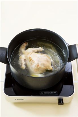 2. 냄비에 닭, 양파, 대파, 통후추를 담고 물 15컵을 부어 30-40분 정도 푹 끓인다.
(Tip 압력솥에서 물을 약간만 넣고 닭을 부드럽게 익히고 나서 나머지 물을 넣으면 빠른 시간 내에 닭을 삶을 수 있다. 또 육수를 만들 때에는 뼈를 함께 삶아야 진한 육수가 만들어지니 뼈가 없는 닭 가슴살만 사용하면 맛이 덜하다.)
