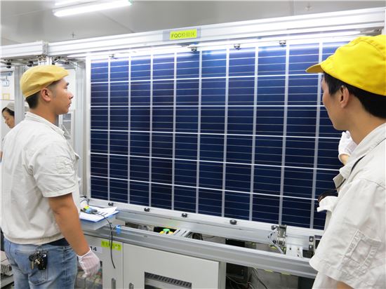 한화큐셀 직원들이 태양광 모듈을 점검하고 있는 모습.