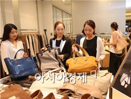 한 백화점에서 여성들이 가방 제품을 살펴보고 있다. 
