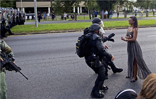 한 흑인 미녀가 드레스를 입고 경찰들과 대립하며 평화적으로 시위 중이다(사진=AP연합뉴스)