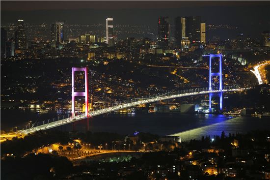 15일(현지시간) 아시아와 유럽 대륙을 잇는 터키 이스탄불의 보스포러스 대교의 주탑이 프랑스 니스에서 발생한 트럭 테러 사건 희생자를 추모하기 위해 프랑스 국기를 의미하는 조명을 비추고 있다. 쿠데타가 발생한 직후 쿠데타 세력은 이 다리를 통제하고 있다.(사진=AP연합) 