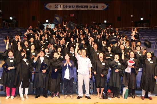 유종필 관악구청장이 자원봉사대학 수료식에서 수료생들과 함께 기뻐하고 있다.