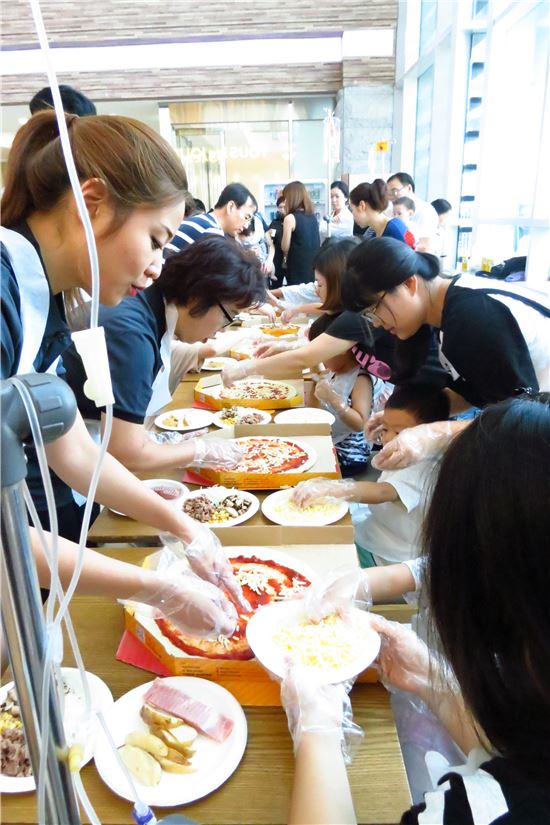 미스터피자 직원들은 20일 강원도 춘천에 위치한 강원대학교 어린이병원을 방문, 어린이 환자와 함께 피자를 만들고 있다. 
 
