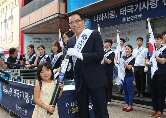8일 조용병 신한은행장(오른쪽)이 서울 중구 신한은행 명동점 앞에서 시민에게 태극기를 나눠주는 행사에 참여해 기념 촬영을 하고 있다. (사진 : 신한은행)