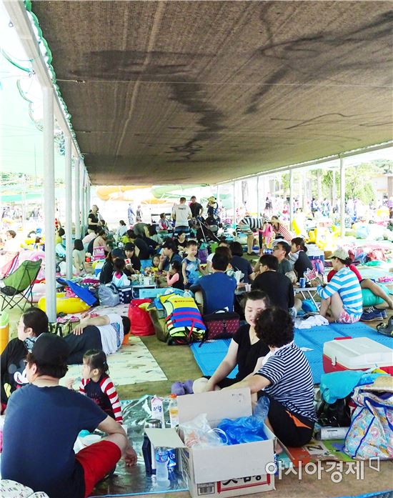 연일 폭염이 기승을 부리는 가운데 13일 함평엑스포공원 물놀이장을 찾은 피서객들이 그늘막에 앉아서 더위를 식하고있다.