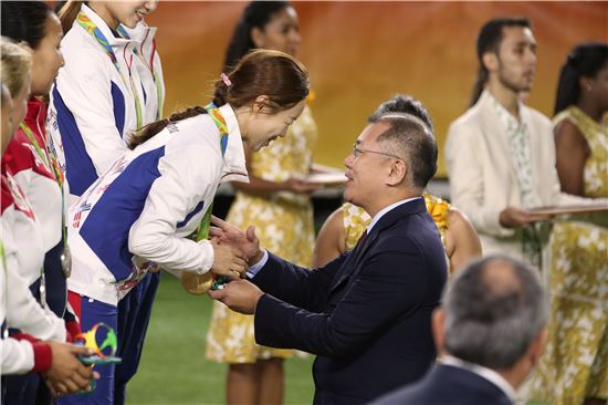정의선 현대차 부회장(오른쪽)이 아시아양궁연맹(WAA) 회장 자격으로 '2016 브라질 리우올림픽' 여자 양궁 단체전에서 금메달을 차지한 한국 대표팀에 시상과 함께 악수를 하면서 활짝 웃고 있다. 사진= 대한양궁협회