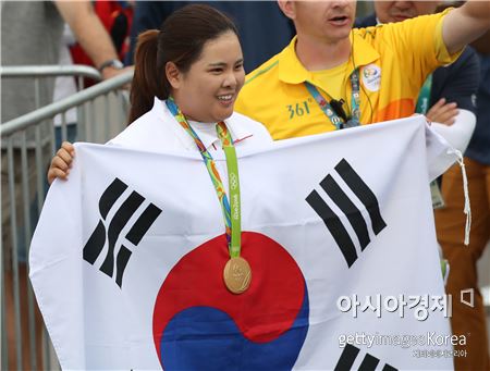 박인비가 리우올림픽 여자골프 우승 직후 금메달을 목에 걸고 태극기를 펼치고 있다. 리우데자네이루(브라질)=Getty images/멀티비츠