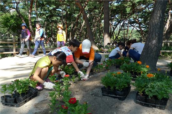 공원 돌보미들이 공원에 꽃을 심는 모습
