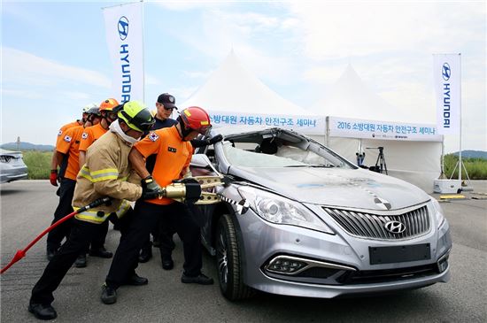 현대차가 교통안전공단과 함께 '제2회 소방대원 자동차 안전구조 세미나'를 25일 개최했다. 세미나에 참가한 소방대원이 친환경차량 절단 실습을 하는 모습.