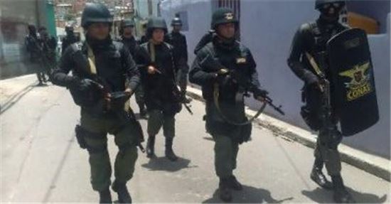 1일(현지시간) 대규모 반정부 시위를 앞둔 베네수엘라 카라카스에 무장한 경찰관이 지나가면서 긴장감이 감돌고 있다