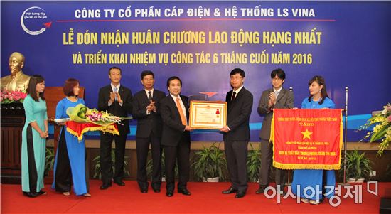 백인재 LS비나 법인장(오른쪽에서 세번째)이 레 단 선 베트남 하이퐁 인민위원회 부위원장(왼쪽에서 다섯번째)으로부터 1급 노동훈장을 받고 있다.(제공=LS전선)