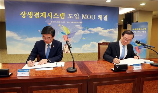 이기권 고용노동부 장관(왼쪽)과 안충영 동반성장위원장이 6일 서울지방고용노동청에서 '상생결제시스템' 도입 업무협약을 체결하고 있다. 

