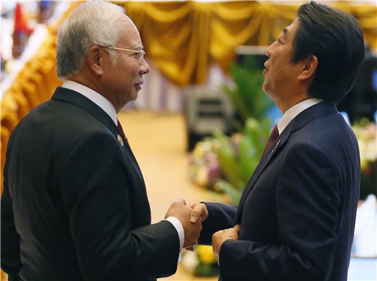 ▲7일 라오스에서 열린 아세안(ASEAN) 정상회의에서 아베 신조 일본 총리(오른쪽)가 나지브 라자크 말레이시아 총리와 만나 담소를 나누고 있다. (AP = 연합뉴스)