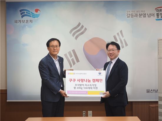 정현교 쿠쿠전자 상무(오른쪽)와 안중엽 울산보훈지청장이 '사랑의 쌀' 나눔 행사에 참석해 기념촬영을 하고 있다. 