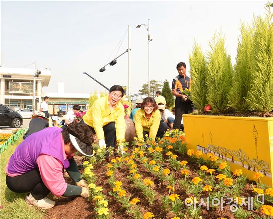 유두석 장성군수가 주민자치센터 회원들과 노란꽃을 식재하고 있다. 사진=장성군