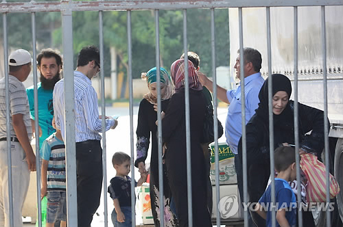 시리아 난민들이 터키 국경검문소를 넘는 모습. (사진=연합뉴스)