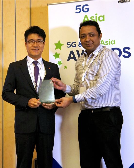 박진효 네트워크기술원장(왼쪽)이 ‘5G & LTE 아시아 어워즈’ 행사 관계자로부터 상을 받고 있다. 
